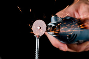 cutting a metal screw head with a miniature tool